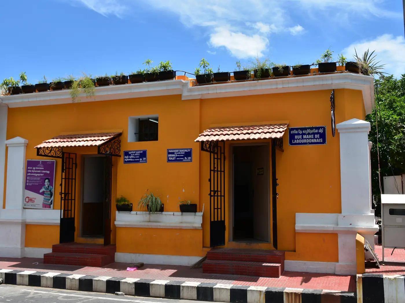 Mustard-yellow colonial building on a White Town street